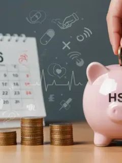 Hand putting coins into an HSA piggy bank for 2026 savings goals